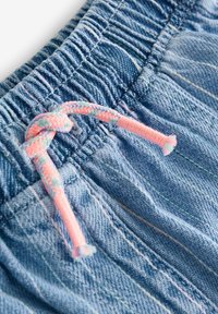 Világoskék farmer rövidnadrág rugalmas derékkal, pink és pasztell színű fonott zsinórral, valamint diszkrét varrási részletekkel.