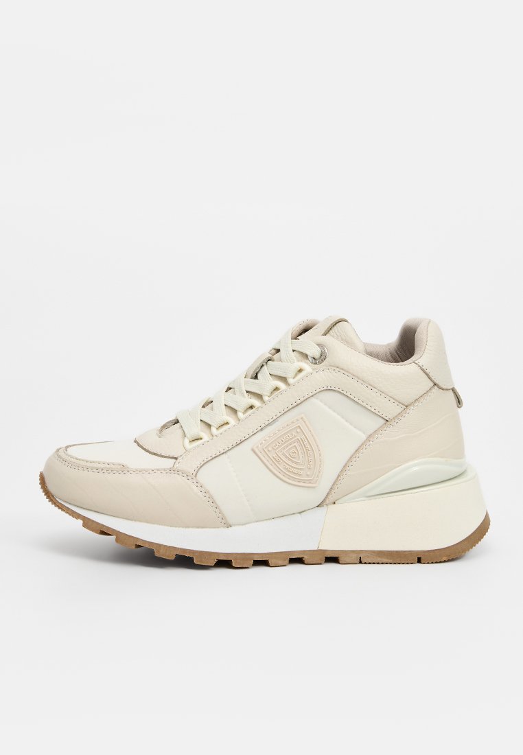 Zapatillas beige con parte superior de cuero texturizado y sintético, que presentan un acolchado en el tobillo, cierre de cordones y una suela blanca gruesa con un dibujo de goma.
