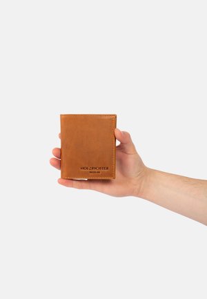 Brown leather wallet with smooth texture, rectangular shape, and embossed "HOLZRICHTER BERLIN" logo at the bottom. Hand holding the wallet.
