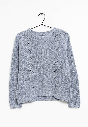 Pull gris clair en maille avec manches longues et motifs en chevrons texturés, suspendu à un cintre noir sur un fond blanc.