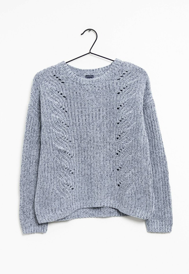 Pull gris clair en maille avec manches longues et motifs en chevrons texturés, suspendu à un cintre noir sur un fond blanc.