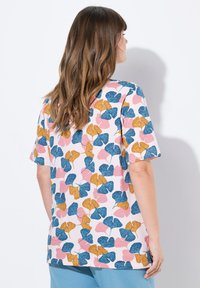 Camiseta de manga corta color rosa con un patrón de hojas de ginkgo en tonos azul, amarillo y rosa; corte relajado, fabricada en algodón suave.