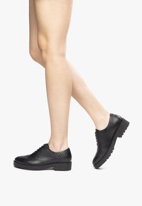 Zwarte leren veterschoenen met een brogue ontwerp, met een ronde neus, gestructureerde accenten en een dikke zool met smalle inkepingen.