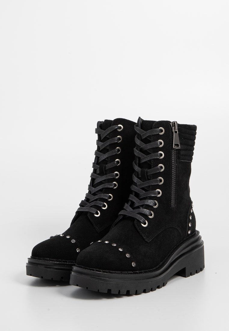 Czarne zamszowe botki za kostkę z zaokrąglonym noskiem, sznurowaniem z przodu, zamkiem błyskawicznym z boku oraz ćwiekowanymi akcentami na nosku i obcasie. Gruba gumowa podeszwa.