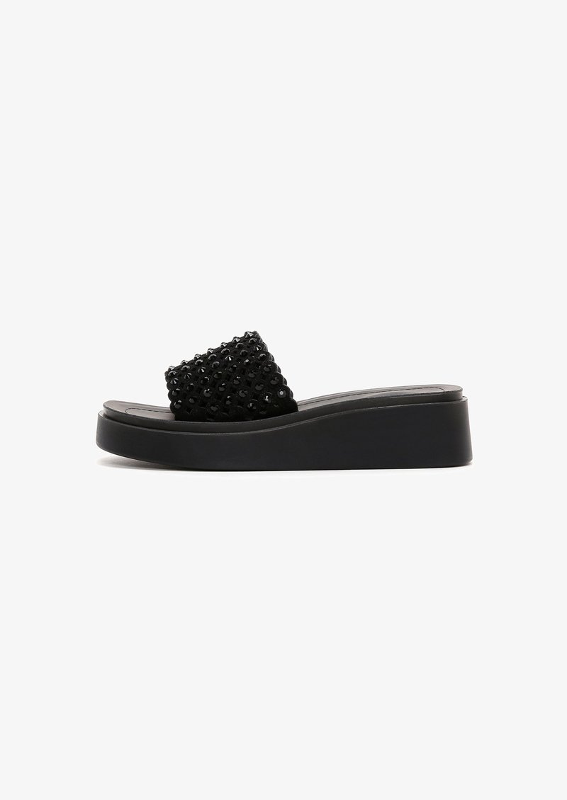 Sandale à talon compensé noire avec dessus texturé décoré de paillettes, semelle plate et design à bout rond. Matériau doux avec une finition lisse.