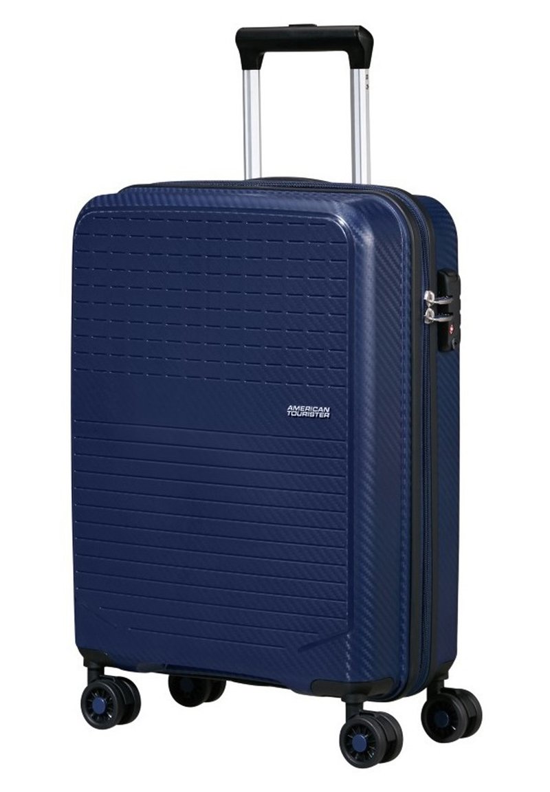 Valigia rigida blu navy con superficie testurizzata, due ruote lisce, manico estraibile e chiusura a doppia zip.