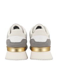 Sneaker grigie e bianche con parte superiore in mesh testurizzato, dettagli in suede e un particolare metallic oro sul tallone. Design minimalista e suola curva.