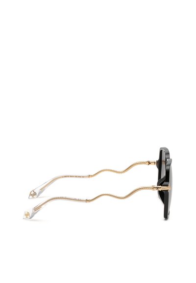 Lunettes de soleil noires avec branches ondulées texturées dorées et embouts transparents avec accents dorés, vues de côté.