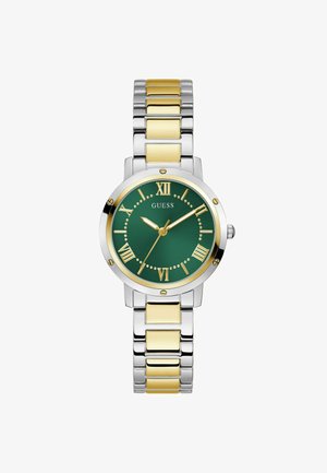 Ümmargune kell, millel on roheline kellanägu kuldsete Rooma numbritega, hõbedane ja kuldne roostevabast terasest rihm ning poleeritud hõbedane äär.