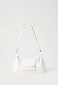 Valge õlakott õhukese rihmaga ja esikülje taskuga, millel on väike dekoratiivne lips, tavalise tausta ees.