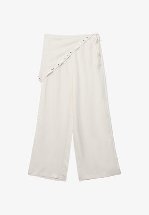 Široke krem hlače s asimetričnim preklopom u struku, pričvršćene bočnim trakama i ukrašene malim metalnim nitnama.