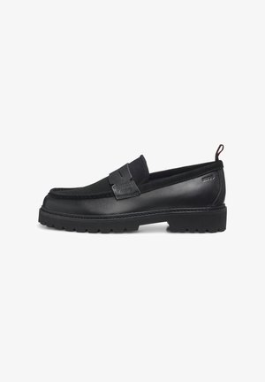 Mocassins noirs avec un corps en cuir lisse, une semelle en caoutchouc et des accents texturés sur la partie supérieure. Ils présentent une bordure cousue et un design à enfiler.