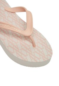 Infradito rosa in gomma con una suola bianca testurizzata caratterizzata da un motivo geometrico. Cinghie sottili di un tenero colore rosa, con il marchio "AX."