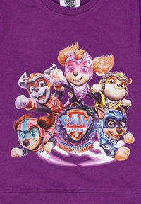 Sudadera morada con un gráfico colorido de cinco perros de dibujos animados de "Paw Patrol", con una insignia central que dice "Mighty Movie".