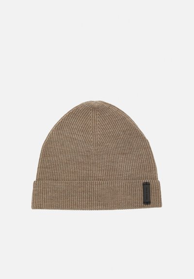 Gorro de malha castanho com textura canelada, com uma dobra na parte inferior e uma pequena etiqueta de marca preta ao lado. Material suave e macio.