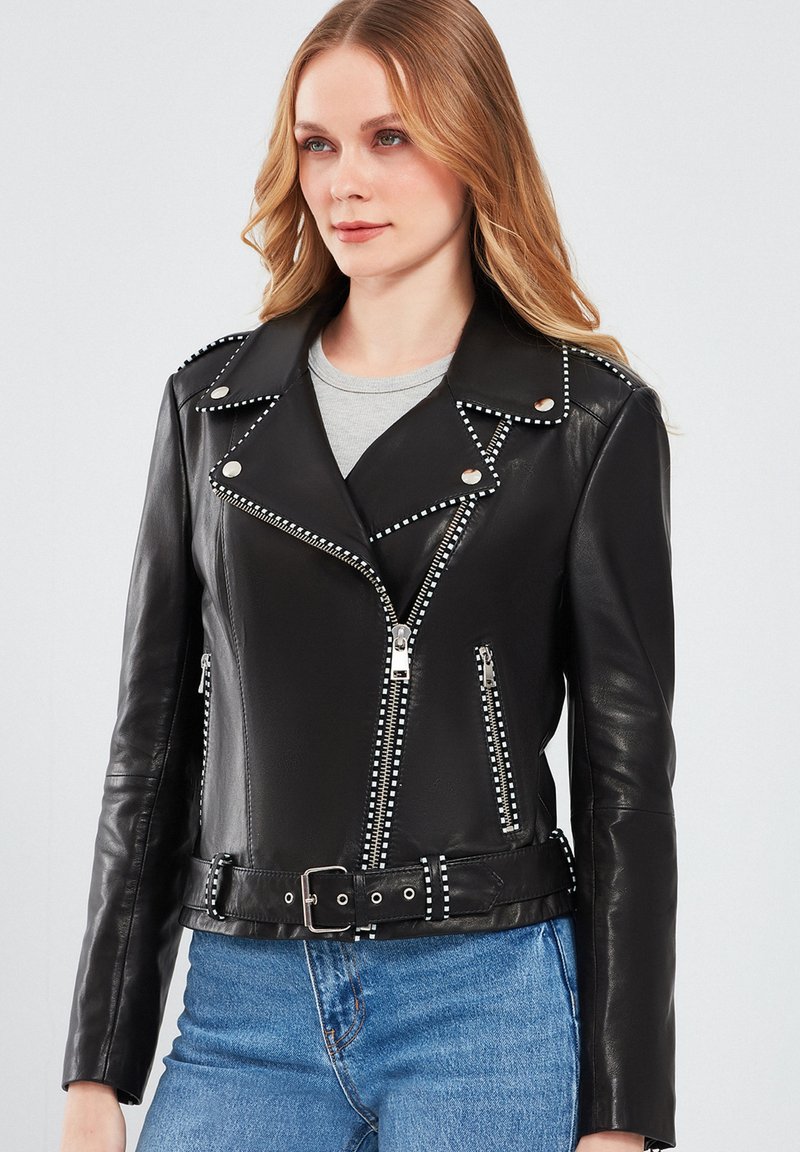 Zwart leren motorjack met zilveren studs langs de kraag en ritsen, voorzien van een ceintuur in de taille en een aansluitend ontwerp.