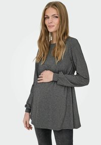 Těhotenský top v tmavě šedé barvě s jemným leskem, kulatým výstřihem, dlouhými rukávy a volným střihem, se skládáním v oblasti pasu.