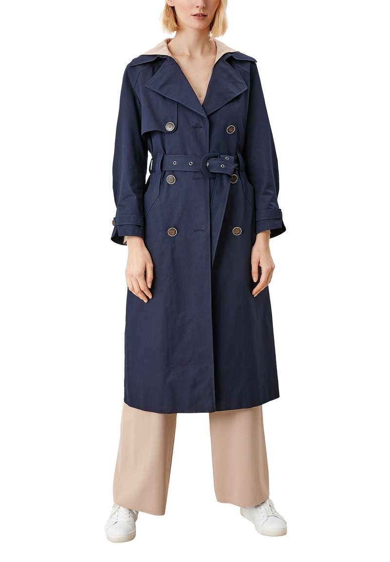 Námornícky trench coat s dvojradovým zapínaním, veľkými klopami a pásom v páse. Vyrobený z hladkého materiálu; obsahuje strieborné gombíky.
