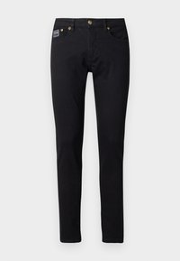 Μαύρα τζιν παντελόνια με στενή γραμμή, που διαθέτουν χρυσά αξεσουάρ, πέντε τσέπες και μία μικρή ετικέτα της μάρκας στην δεξιά τσέπη.