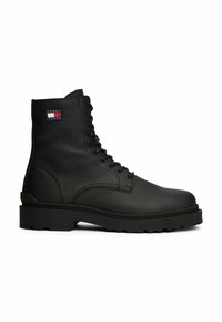 Stivale di pelle nera con superficie texture, design con lacci, suola robusta e una piccola etichetta logo Tommy Jeans sul polpaccio.