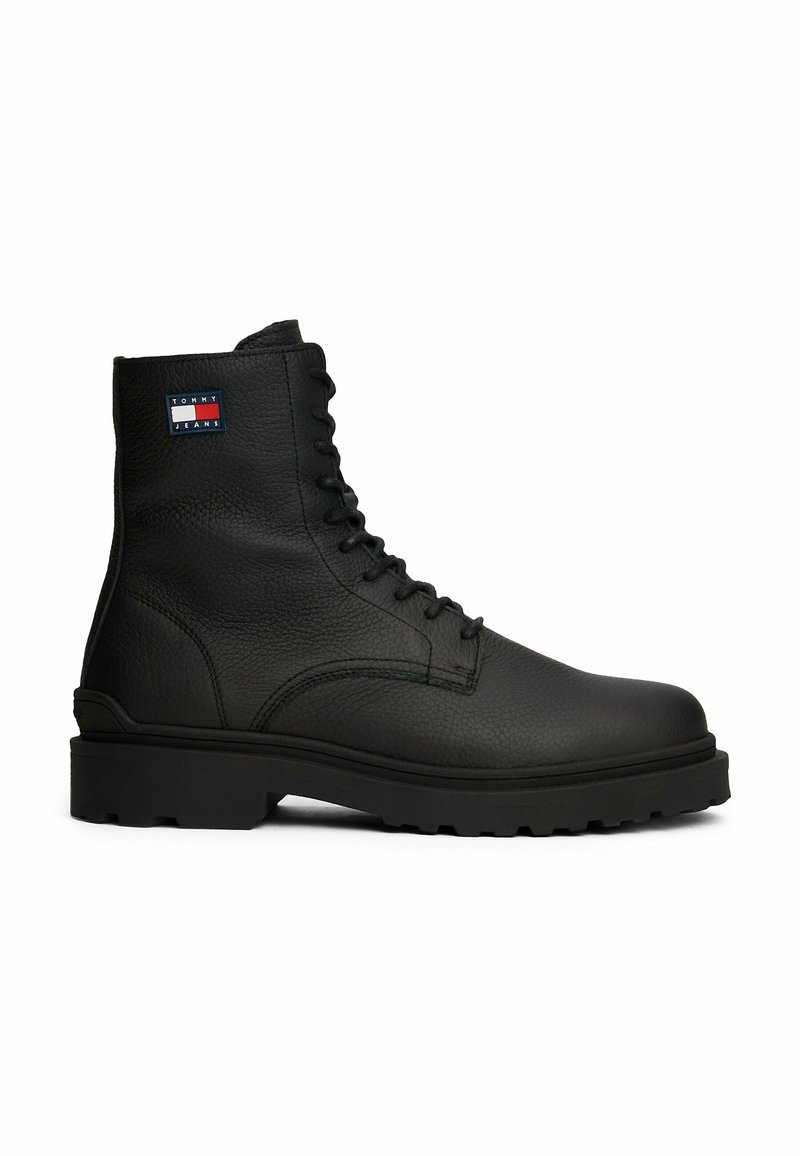 Zwarte leren laars met een textuur, vetersluiting, stevige zool en een klein Tommy Jeans logo op de enkel.