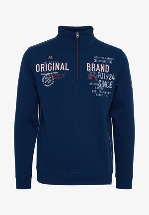 Tumedat sinise värviga keskmise kaelusega ja poolkinnitusga pehme sviiter. Omab erinevaid valge ja punase värvi tekste, ribakätiseid ja logo kleepsu varrukal.