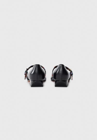 Black leather shoes with a low block heel and colorful woven ankle straps. Smooth texture, minimalistic design, and secure buckle closure.