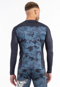 Hosszú ujjú rash guard sötétkék katonai mintával, fekete akcentusokkal. Rugalmasságot és kényelmet biztosító, texturált anyagból készült.