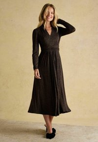 Schwarzes Midi-Kleid mit Wickeldesign, langen Ärmeln und gerafftem Bund. Verfügt über einen dezenten Tierdruck und einen weichen, strukturierten Stoff.