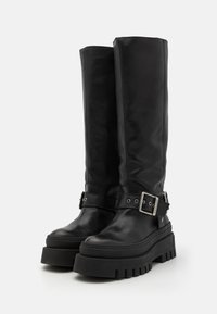 Botas altas de cuero negro hasta la rodilla con una suela de plataforma gruesa, que presentan un llamativo detalle de correa con hebilla y una textura suave.