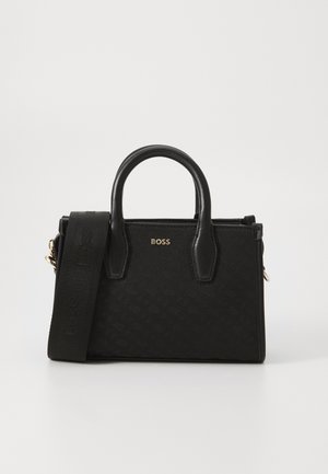 Black handbag featuring a textured fabric, gold hardware, dual handles, and a detachable strap, showcasing a minimalist design.
