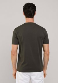T-shirt girocollo a maniche corte di colore verde scuro, realizzato in cotone, con un taglio dritto, texture liscia e senza grafiche visibili.