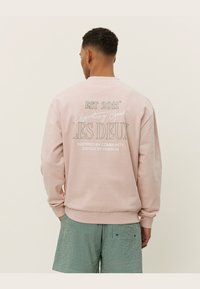 Helle rosa Sweatshirt mit dem Text "EST 2011" und "LES DEUX" auf der Rückseite, Rundhalsausschnitt und gerippten Bündchen. Aus Baumwollmischung.