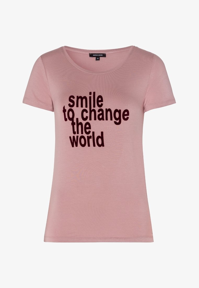 Lysrosa kortærmet T-shirt med rund halsudskæring, der har fed sort tekst: "smil for at ændre verden." Blødt stof med en glat tekstur.