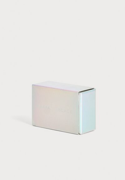 Petite boîte rectangulaire irisée avec un texte en relief subtil sur le côté, posée sur un fond clair uni.