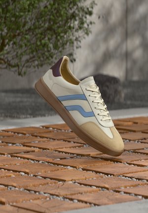 White sneakers with blue and cream stripes, tan suede toe, maroon heel, and textured rubber sole. Shiny laces and logo detail included.