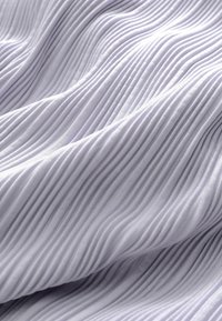 Primer plano de tela suave de color gris claro con una textura acanalada vertical delgada y uniformemente espaciada, con pliegues suaves.