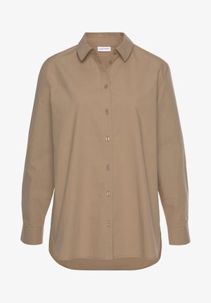 Beige blouse met lange mouwen en knopen, klassieke kraag en afgeronde zoom, met zichtbaar merklabel aan de binnenkant van de kraag.