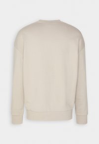 Felpa beige, colletto rotondo, maniche lunghe, polsini e orlo a costine, texture liscia, design minimale, colore unico senza motivi visibili.
