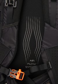 Black backpack interior featuring a mesh back panel with white airflow lines. Includes a bright orange buckle and adjustable straps.