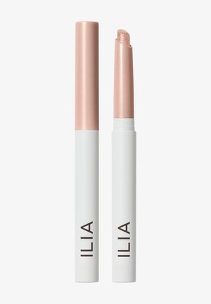 Deux sticks de maquillage blancs et or rose avec la marque ILIA, l’un avec le capuchon et l’autre avec le produit sorti.