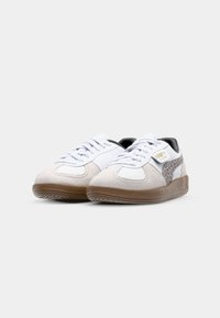 Zapatillas deportivas con parte superior de cuero blanco, acentos de ante beige, estampado de leopardo en el costado y suela de goma marrón. Diseño con cordones y cuello acolchado.