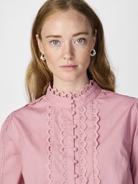 Pink blouse featuring a high collar, button front, and lace trim details. Soft cotton material with decorative loop accents.