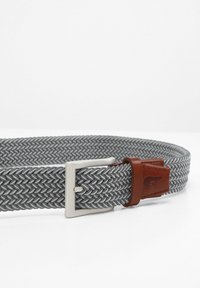 Geweven grijze elastische riem met een zilverkleurige metalen gesp en een bruine leren accenten. Bevat een visgraatpatroon en is verstelbaar.