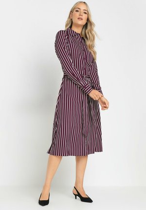 Abito lungo bordeaux con strisce bianche, dotato di colletto, maniche lunghe, vita con cintura e gonna svasata. Il materiale sembra liscio.