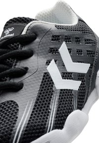 Schwarzer und grauer Sportschuh mit einem strukturierten Mesh-Obermaterial, weißen Logo-Akzenten und kontrastierenden schwarzen Schnürsenkeln. Verfügt über eine flexible Gummisohle.