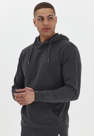 Hoodie gris foncé avec une poche kangourou, capuche réglable avec cordon, poignets côtelés et tissu texturé, présenté sur un modèle.