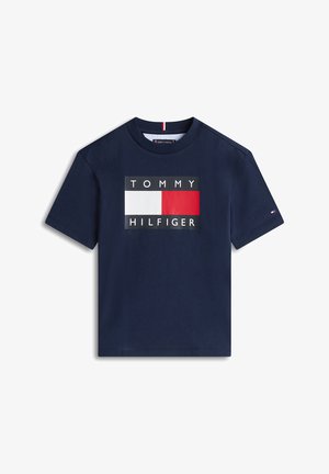 Μπλε ναυτικό βαμβακερό T-shirt με ορθογώνιο λογότυπο που γράφει «TOMMY» σε λευκό και «HILFIGER» σε μαύρο, διακοσμημένο με κόκκινους και λευκούς κύβους.