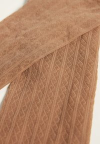 Tejido marrón texturizado con un patrón de diamantes, con un aspecto suave y tejido. El material tiene una textura ligeramente elevada en toda su superficie.