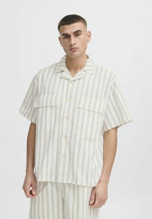 Short-sleeve, button-up shirt in cream with vertical stripes in light brown. Features two chest pockets and a relaxed fit.